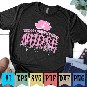 May include: Black t-shirt featuring a pink nurse's cap and the word "NURSE" in pink script. The design includes a heartbeat line and floral accents. The shirt is a crew neck.