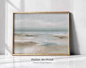 Op de afbeelding: Een ingelijst landschapsschilderij met een goudkleurige lijst. Het kunstwerk toont een serene strandscène met gedempte tinten blauw, beige en grijs. De tekst "Atelier de Muse" en "Timeless Vintage Elegance" staat onderaan de lijst.