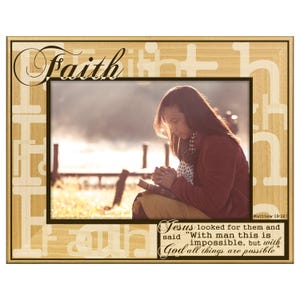 May include: Wooden picture frame with the word "Faith" in elegant script. The frame surrounds a photo of a person praying, with text from Matthew 19:26. The frame has a light wood grain finish.