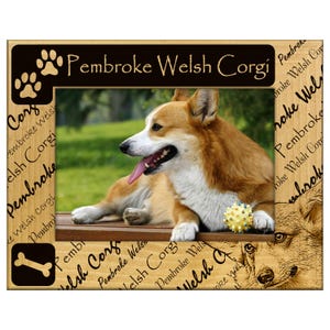 May include: Wooden photo frame featuring a Pembroke Welsh Corgi dog. The frame has a brown and tan color scheme with paw prints and a bone graphic. The dog is lying down with its tongue out, and a yellow ball is in front of it.
