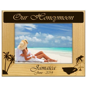 May include: Wooden picture frame with the words "Our Honeymoon" at the top and "Jamaica June - 2014" at the bottom. The frame holds a photo of a couple on a beach. Palm tree silhouettes are on the frame.