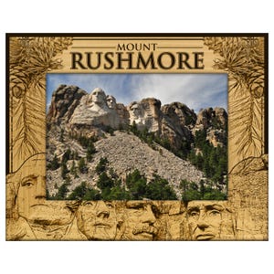 May include: Wooden Mount Rushmore picture frame. The frame features an image of the Mount Rushmore National Memorial with the faces of U.S. Presidents carved into the mountain. The frame is made of light brown wood with the words "MOUNT RUSHMORE" at the top.