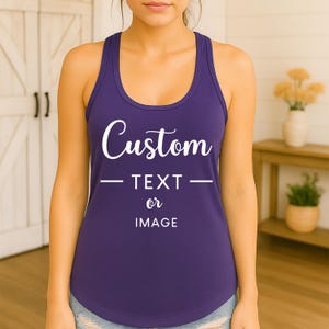 May include: A purple racerback tank top with the word "Custom" in white script. Below the word "Custom" is the text "TEXT or IMAGE" in white. The tank top is a solid color and has a scoop neck.