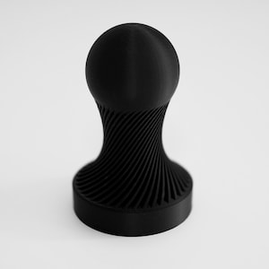 May include: A black espresso tamper, 3D-printed with a spherical top and a spiraling, ridged handle. The base is a flat, circular disc. The design is modern and minimalist. Suitable for coffee lovers.