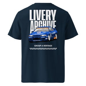 May include: Navy blue t-shirt featuring a graphic of a blue race car with white accents. The text "LIVERY ARCHIVE" is above the car, and "GROUP A HERITAGE" is below. A checkered flag design is at the bottom.