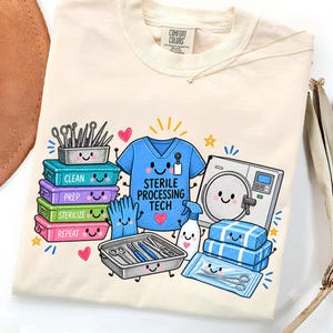 Puede incluir: Una camiseta color crema con un gráfico colorido de equipo médico con caras sonrientes. El diseño incluye una casaca azul con el texto Sterile Processing Tech, contenedores apilados etiquetados Clean, Prep, Sterilize, Repeat e instrumentos.