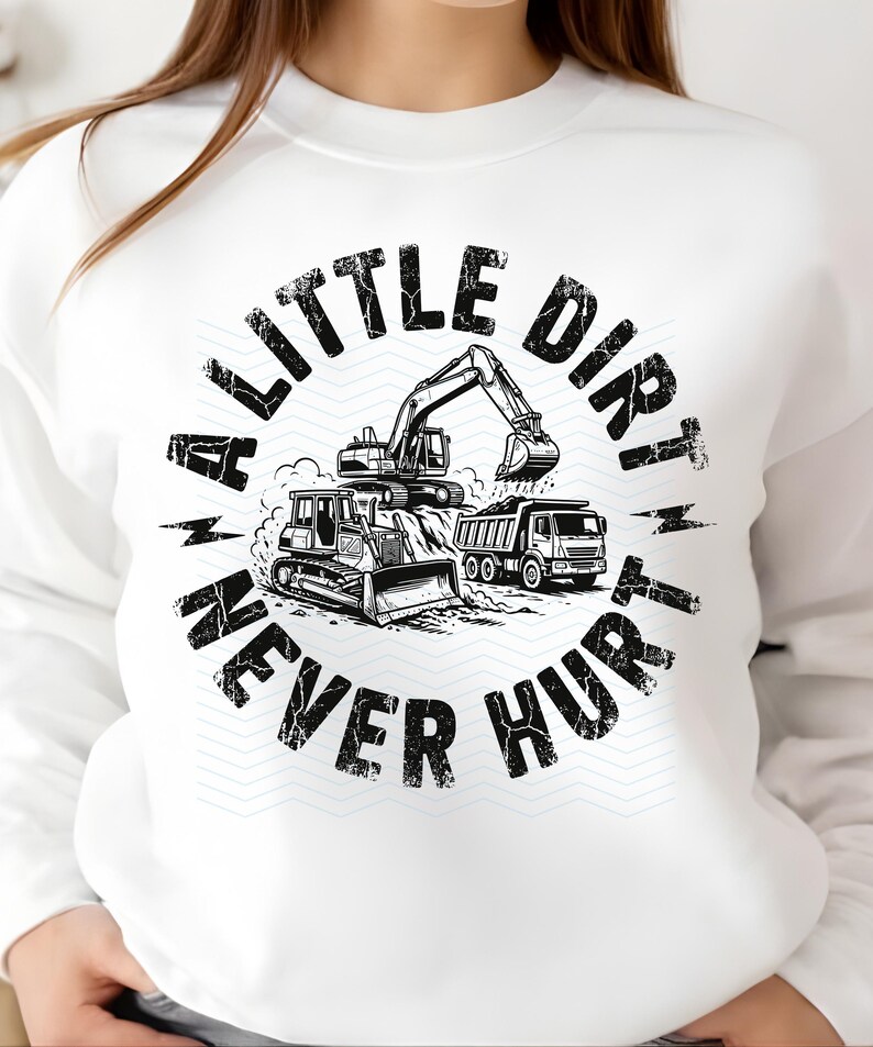 May include: White sweatshirt with a black and white graphic. The graphic features construction vehicles, including a bulldozer, excavator, and dump truck, with the text "A Little Dirt Never Hurt".