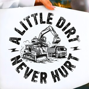 May include: White t-shirt featuring a black and white illustration of construction vehicles, including an excavator, bulldozer, and dump truck. The text "A LITTLE DIRT NEVER HURT" is printed in a circular design around the vehicles.