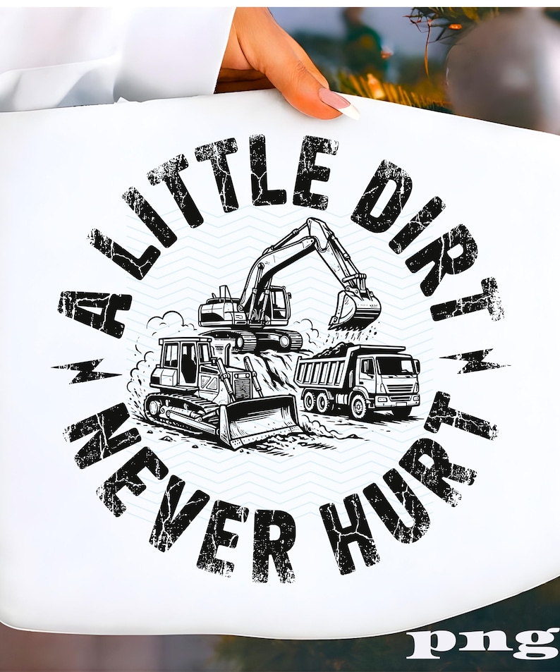 May include: White t-shirt featuring a black and white illustration of construction vehicles, including an excavator, bulldozer, and dump truck. The text "A LITTLE DIRT NEVER HURT" is printed in a circular design around the vehicles.