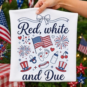 May include: A white fabric square featuring the text Red, white and Due in blue script. The design includes a central American flag, fireworks, baby footprints with hearts, a pacifier, a baby bottle, a hot dog, and two top hats in red and blue.