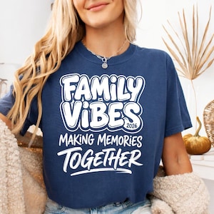 May include: Navy blue t-shirt with the words "FAMILY VIBES 2026 MAKING MEMORIES TOGETHER" in white, bold, bubble letters. The shirt is a casual style, suitable for family gatherings or events.