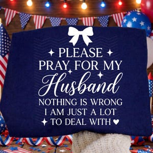 May include: A navy blue cushion with the text "PLEASE PRAY FOR MY Husband NOTHING IS WRONG I AM JUST A LOT TO DEAL WITH." The cushion has a white bow and star accents. Patriotic theme with flags and balloons.