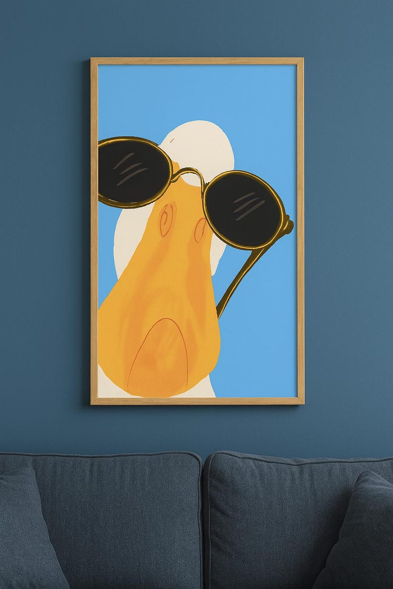 May include: A framed art print featuring a cartoon duck wearing sunglasses. The duck has a yellow beak and is set against a blue background. The sunglasses are black with gold frames, adding a touch of style.