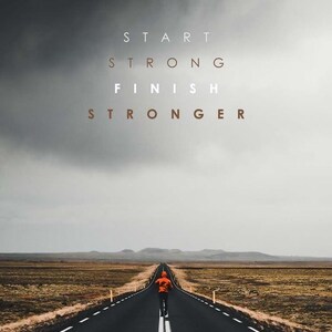 K&ouml;nnte beinhalten: Eine Person geht auf einer langen, geraden Stra&szlig;e unter einem dunklen Himmel. Der Text "START STRONG FINISH STRONGER" steht oben. Die Person tr&auml;gt eine orangefarbene Jacke.
