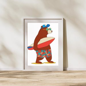 Puede incluir: Una impresión enmarcada que presenta un oso de dibujos animados con gafas de sol y una gorra azul, sosteniendo una tabla de surf roja y blanca. El oso lleva un bañador colorido con un estampado floral. La impresión está en un marco blanco.