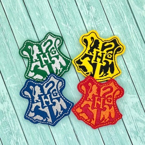 May include: Four embroidered felt patches featuring the Hogwarts house crests. The crests are in green, yellow, blue, and orange. Each crest features a different animal and the house name.