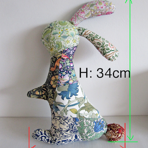 May include: A patchwork fabric bunny toy with a long, floppy ear. The bunny is sitting on a white surface and is 34 cm tall and 24 cm wide.