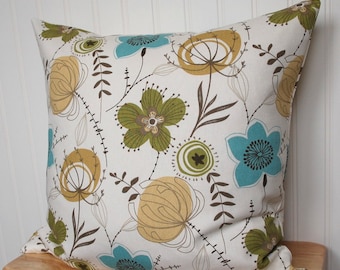 May include: A white pillow with a floral pattern in shades of green, brown, and blue. The flowers are stylized and abstract, with a modern design.