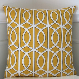 May include: A yellow throw pillow with a white geometric pattern. The pattern is made up of interlocking circles and ovals.