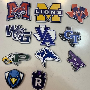 May include: A collection of colorful school spirit emblems featuring various mascots and team names. Designs include a horse, lion, eagle, and wolf, with text such as "BOYD", "LIONS", and "NORTH".