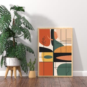 Könnte beinhalten: Ein gerahmter Kunstdruck mit abstraktem Design im Stil der Moderne. Das Kunstwerk zeigt geometrische Formen in Orange, Schwarz, Gelb, Grün und Beige mit dünnen schwarzen Linien. Der Rahmen hat eine helle Holzfarbe. Der Druck wird auf einem Holzboden präsentiert.
