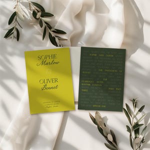 May include: A wedding invitation suite featuring a lime green card with the names "Sophie Marlow & Oliver Bennet" and a dark green card with event details. The cards are set on a white fabric with olive branches.