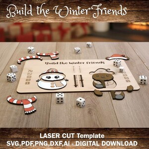 Op de afbeelding: Een lasergesneden houten sjabloon voor een winters thema spel. Het spel bevat een sneeuwpop en een beer, dobbelstenen en accessoires zoals sjaals en hoeden. De tekst "Build the Winter Friends" en "LASER CUT Template" zijn zichtbaar.