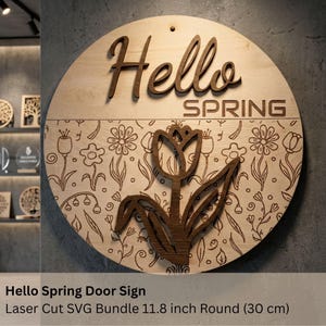 Könnte beinhalten: Rundes Türschild aus Holz mit den Worten "Hello Spring" in dunkelbraunen, lasergeschnittenen Buchstaben. Das Schild zeigt ein Blumendesign und eine große Tulpe. Das Schild hat einen Durchmesser von 30 cm.