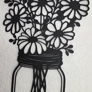 May include: A white ceramic mug with a black handle and the text "But First, Coffee" in a black, bold font. The mug is sitting on a white surface.