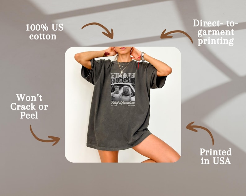 Pu&ograve; includere: T-shirt grigio scuro con la scritta "GETTING MEOWIED" e una foto di gatti. Realizzata in 100% cotone americano e stampata negli Stati Uniti. La stampa &egrave; diretta sul capo e non si crepa.