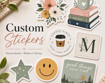 May include: A collection of custom stickers featuring various designs including a floral bouquet, a stack of books with a coffee mug, a circular coffee cup graphic with the text COFFEE FIRST GOOD VIBES ALWAYS, a letter M, a star, a smiley face, and a landscape.