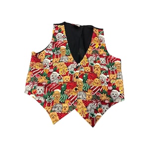 May include: A festive, button-up vest featuring a repeating pattern of various dog breeds, wrapped gifts, and holiday decorations on a red background. The vest has a black back and a V-neck design, perfect for a holiday party or dog lover.