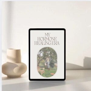 May include: A digital tablet screen displaying the text "MY HORMONE HEALING ERA" in a white sans-serif font. The background image is a photo of a person standing on a ladder in an orchard picking fruit.