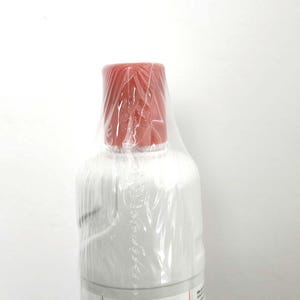 Pode incluir: Uma caneca de cerâmica branca com uma alça preta e o texto "But First, Coffee" em preto, em negrito. A caneca está sobre uma superfície branca.