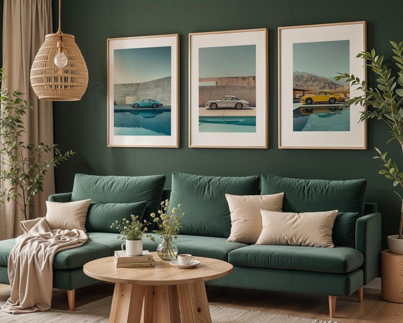 May include: Three framed art prints featuring vintage cars in teal, silver, and yellow, each parked near a pool. The prints are displayed above a green velvet sofa with beige pillows, creating a stylish living room decor.