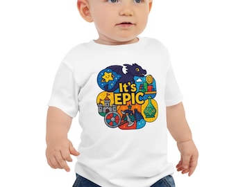 May include: White short-sleeved baby t-shirt with a colourful graphic that says "It's EPIC". The graphic includes a dragon, castle, and other fantasy-themed illustrations. The baby is wearing blue jeans.