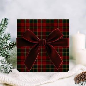 May include: A square gift box with a red and green plaid pattern, wrapped with a deep red velvet bow. The bow is centered on the box, creating a festive and elegant presentation. The box is likely for a holiday or special occasion.