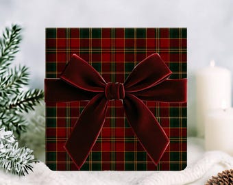 May include: A square gift box with a red and green plaid pattern, wrapped with a deep red velvet bow. The bow is centered on the box, creating a festive and elegant presentation. The box is likely for a holiday or special occasion.