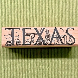 May include: A wooden stamp with the word "TEXAS" in black, each letter incorporating iconic Texas imagery. The design includes a star, longhorn, windmill, and a building, all on a light wood background.
