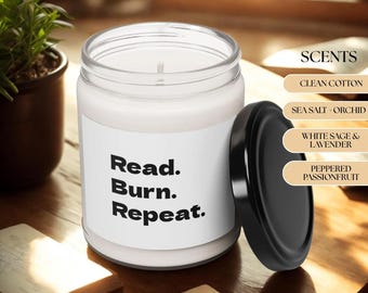 May include: A white candle in a clear glass jar with a black lid. The candle has the text "Read. Burn. Repeat." on the label. The image also shows a list of scents: Clean Cotton, Sea Salt + Orchid, White Sage & Lavender, and Peppered Passionfruit.