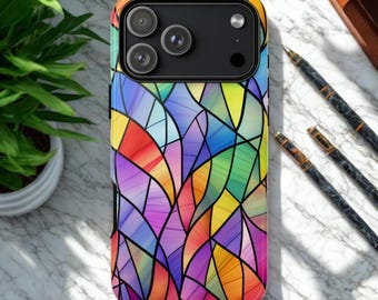 May include: A colorful phone case with a stained glass design. The case features a vibrant pattern of intersecting lines and shapes in shades of red, yellow, green, blue, and purple. The phone case has a black camera module.