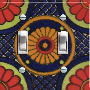 Puede incluir: Una tapa de interruptor de luz con un diseño geométrico colorido que presenta colores rojo, amarillo, azul y verde. El diseño recuerda a los azulejos tradicionales mexicanos. La tapa del interruptor tiene dos interruptores de palanca etiquetados como "ON".