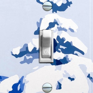 May include: A white light switch with a blue and white stylized tree design. The switch is labeled "ON".