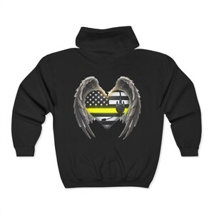 May include: Black hooded sweatshirt with a graphic of a heart with wings. The heart is made up of the American flag with a yellow stripe across the middle and a black and white police stripe. A black headset is on the heart.