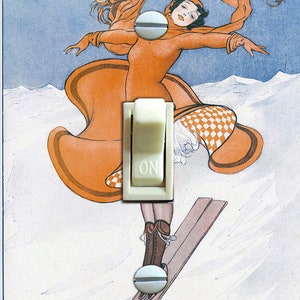 May include: A vintage postcard featuring a woman in a checkered skirt and orange coat skiing down a snowy mountain. The text on the postcard reads "La Vie Parisienne Le Ski, Sport Exquis".