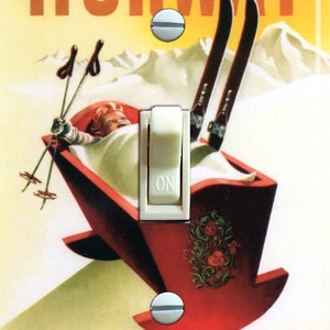 May include: A vintage-style light switch cover featuring a colourful illustration of a person in a sled with skis and ski poles. The text "NORWAY" and "THE CRADLE OF SKI-ING" is printed on the cover.