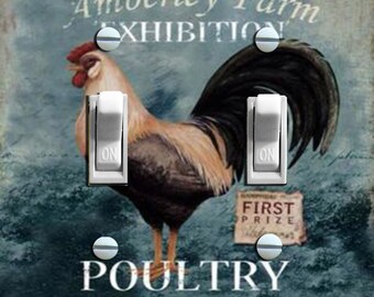 Può includere: Una placca per interruttore di stile vintage con un gallo e il testo "Amberley Farm Exhibition First Prize Poultry Sold Here". La placca per interruttore ha due interruttori a levetta con la parola "ON" stampata su di essi.