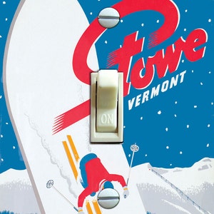 May include: A vintage-style light switch cover featuring a skier on a snowy mountain with the text "There's always snow in Stowe, Vermont".