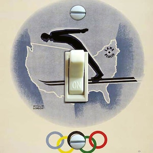May include: A vintage poster for the III Olympic Winter Games held in Lake Placid, USA, February 4-13, 1932. The poster features a skier jumping off a ramp, a map of the United States, and the Olympic rings.