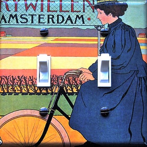 May include: A vintage-style light switch plate featuring a woman riding a bicycle in a field of flowers. The text "RIJWIELEN AMSTERDAM." is printed at the top of the plate.
